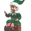 Pièce de table, elfe en vert, assis sur un cadeau de Noël